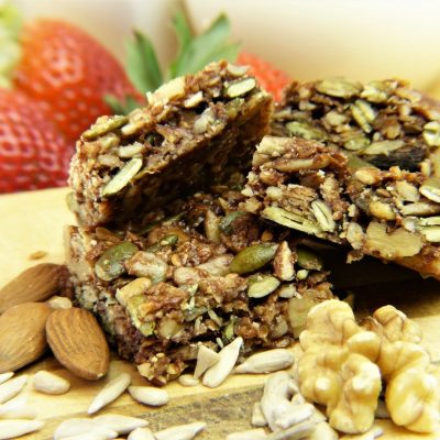 Seed Crackers surrounded by a blurred background of strawberries and nuts